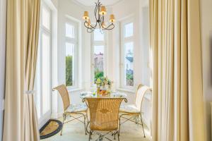 una sala da pranzo con tavolo, sedie e finestre di Villa Gruner App 1a a Zinnowitz