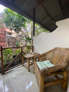 a porch with a bench and a table at Bintang Guesthouse in Gili Trawangan
