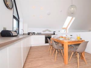 a kitchen with a wooden table and chairs at 3 Bed in Westward Ho 75539 in Northam