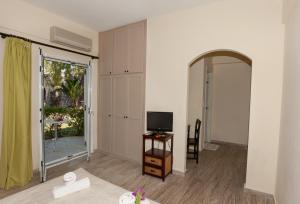a living room with a television and a door to a patio at Rastoni in Spílion