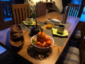 a wooden table with a bowl of fruit on it at Chambre d’hôtes in Les Chapelles