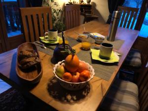 uma mesa de madeira com uma tigela de fruta em Chambre d’hôtes em Les Chapelles