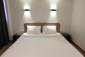1 dormitorio con 1 cama con 2 luces encima en U-Thong Hotel, en Phitsanulok