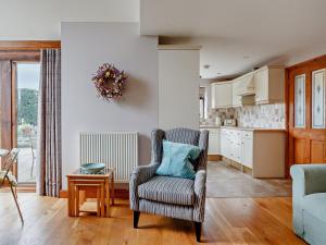 a living room with a chair and a kitchen at 1 Bed in St Briavels 73584 in Saint Briavels