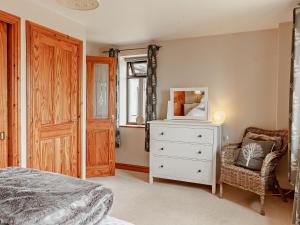 a bedroom with a bed and a dresser and a mirror at 1 Bed in St Briavels 73584 in Saint Briavels