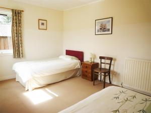 Tomdoun的住宿－3 Bed in Invergarry CA195，一间卧室配有两张床、一把椅子和一张桌子