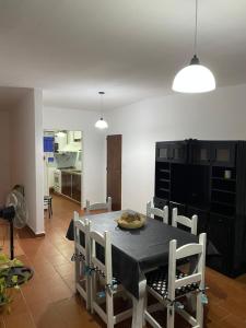 une salle à manger avec une table noire et des chaises blanches dans l'établissement departamentoAA, à Villa Carlos Paz