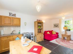 a kitchen with a table and a red couch at 1 Bed in Edzell CA217 in Edzell