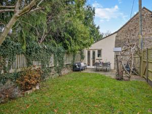 a backyard with a stone wall and a house at 2 Bed in Coleford 78181 in Symonds Yat