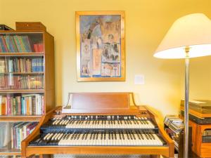 a organ in a room with a lamp and books at 6 bed in Lairg CA301 in Lairg