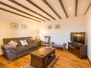 sala de estar con sofá y TV en 2 bed in Loch Ness CA315, en Drumnadrochit
