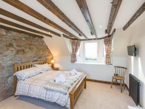 a bedroom with a bed and a stone wall at 2 bed in Loch Ness CA315 in Drumnadrochit