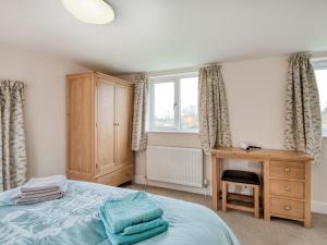 a bedroom with a bed and a desk and a window at 1 bed property in Godshill 77796 in Downton