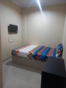 een slaapkamer met een bed en een tv aan de muur bij Barada Poris 