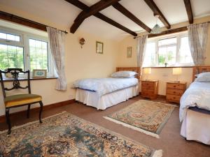 a bedroom with two beds and a chair at 2 Bed in Crickhowell 76431 in Llangenny