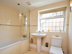 a bathroom with a sink and a toilet and a bath tub at 2 Bed in Crickhowell 76431 in Llangenny