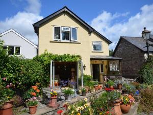 a house with a lot of flowers in pots at 2 Bed in Crickhowell 76431 in Llangenny