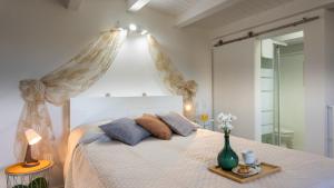 a bedroom with a white bed with a canopy at PROFUMO DI ZAGARA 6&2 Emma Villas in Ispica