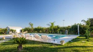 a swimming pool with lounge chairs in a yard at PROFUMO DI ZAGARA 6&2 Emma Villas in Ispica