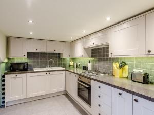 eine weiße Küche mit weißen Schränken und Geräten in der Unterkunft 1 bed property in Tansley 61938 in Tansley