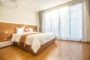 a bedroom with a large bed and a large window at Sumitomo 15 Apartment - No 27 Lane 39 Linh Lang Street in Hanoi
