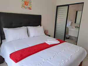 a large white bed with a red blanket on it at THE BLYDE Holiday Apartments in Pretoria