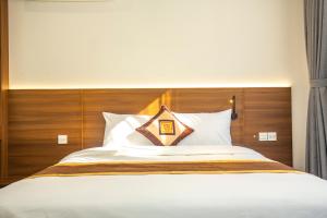 a bed with a wooden headboard and white pillows at Sumitomo 15 Apartment - No 27 Lane 39 Linh Lang Street in Hanoi