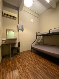 Zimmer mit einem Etagenbett und einem Schreibtisch in der Unterkunft Backpacker Cozy Corner Guesthouse in Singapur