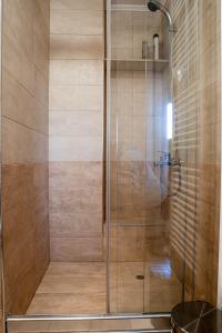 a shower with a glass door in a bathroom at Estia guest house in Olympia