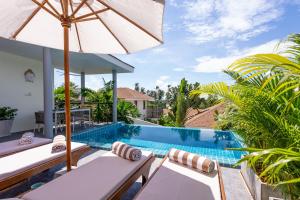 Hua Thanon BeachにあるVilla Léa 2 bedrooms pool wifi Netflixの屋外プール(長椅子、パラソル付)