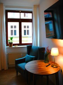 a living room with a table and a couch and a window at Suite - Mein Ankerplatz in Stralsund
