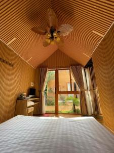 a bedroom with a ceiling fan and a bed at Lá Garden Homestay in Long Xuyên