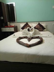 two swans forming a heart on a bed at HOTEL ROYAL INN,NUWAKOT. in Trisūli Bāzār