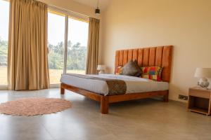 ein Schlafzimmer mit einem Bett und einem großen Fenster in der Unterkunft La Luxo in Anjuna