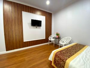 - une chambre avec un lit et une télévision murale dans l'établissement Motel Happy House, à Bạc Liêu