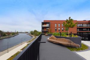 a bridge with two benches next to a river at Elite Apartments Sienna Grobla Prestige in Gdańsk