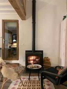 a living room with a wood stove in a room at Cozy Catalan Cottage in Reynès