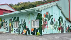 a building with a mural of flowers on it at 31 Backpack Guest House in Renai