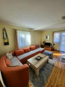 uma sala de estar com um sofá e uma mesa de centro em Apartments center Zorić em Žabljak