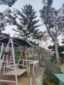 einen Picknicktisch mit einem Baum im Hintergrund in der Unterkunft The Sweven NeerVan in Rishikesh