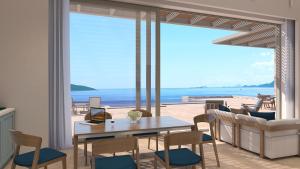 Una sala de estar con una mesa y sillas y el océano. en Villa Noesis, en Katomérion