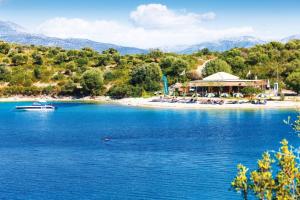un complejo en una playa con un barco en el agua en Villa Noesis, en Katomérion