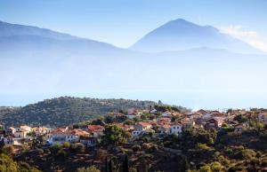 un pueblo en una colina con una montaña en el fondo en Villa Noesis, en Katomérion 5 fotos más