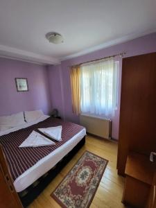 een kleine slaapkamer met een bed en een raam bij Apartments center Zorić in Žabljak