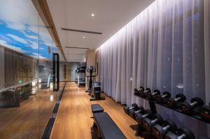 a gym with black chairs and a wall of curtains at GINCO Hotel Guangzhou Baiyun Airport in Guangzhou
