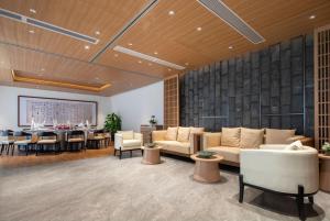 un soggiorno con divani, tavolo e sedie di GINCO Hotel Guangzhou Baiyun Airport a Canton