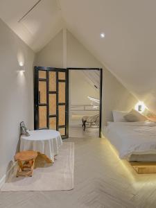1 dormitorio con cama, mesa y ventana en Compass North - PoolVilla & BBQ en Ban Pa Lan