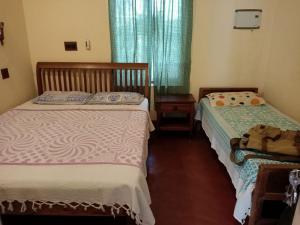 1 dormitorio con 2 camas y mesa en Adams Wood House Ayurveda Homestay Kochi, en Kochi