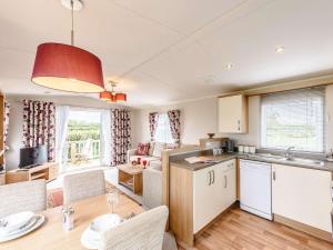 a kitchen and living room with a table and chairs at 2 Bed in Newborough 82559 in Brynsiencyn