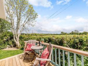 a patio with two chairs and a table on a deck at 2 Bed in Newborough 82559 in Brynsiencyn